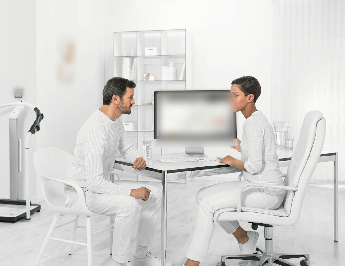 Bright consultation room with a patient and clinician