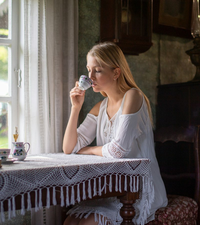 Woman enjoying a cup of tea by the window